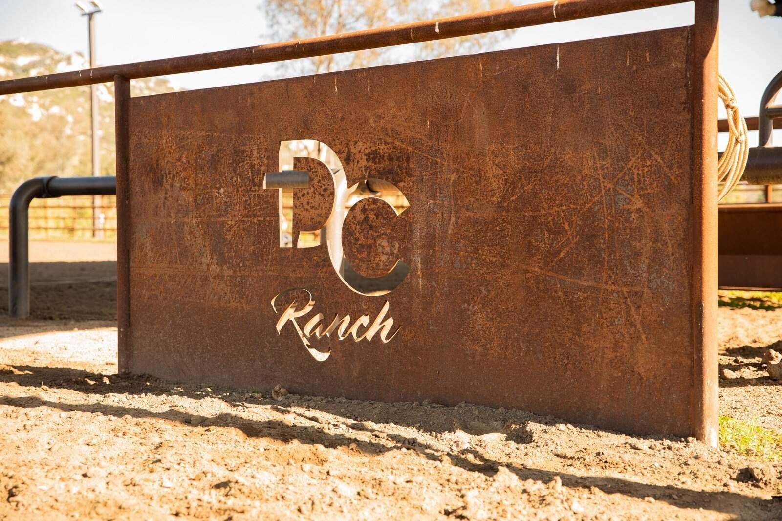 Weathered drill-pipe ranch fencing across a custom horse property, detail
