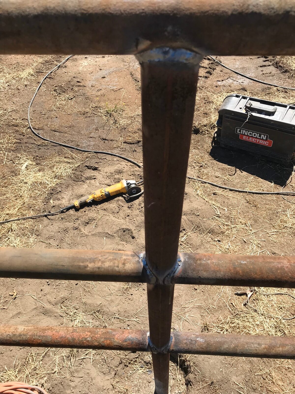 Weathered drill-pipe ranch fencing across a custom horse property