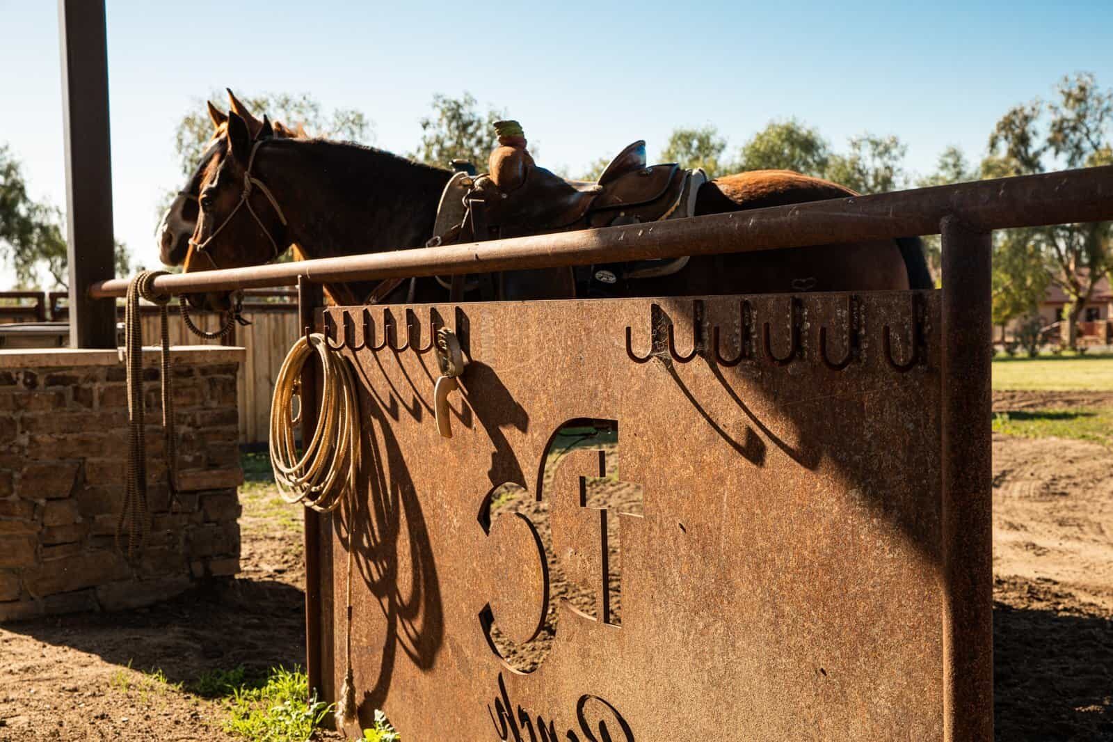 Weathered drill-pipe ranch fencing across a custom horse property, on-site fabrication