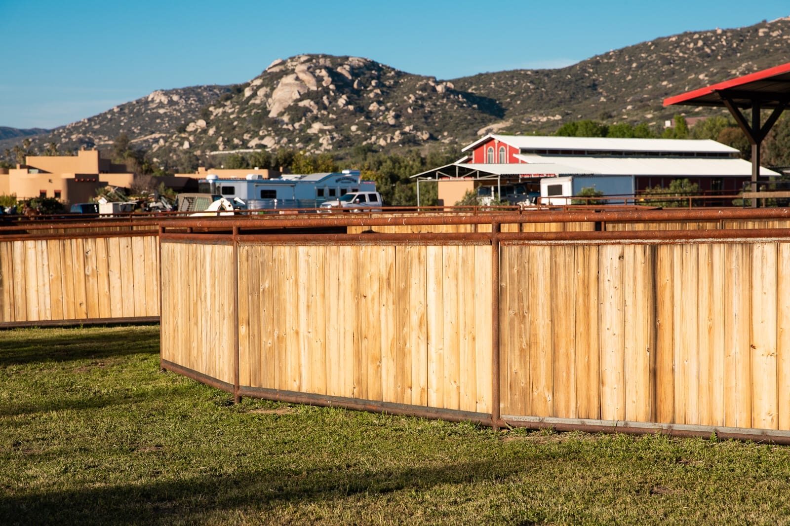 Weathered drill-pipe ranch fencing across a custom horse property, detail